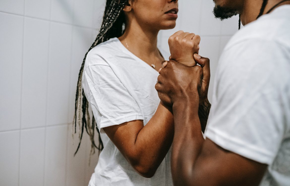 Crop anonymous black couple arguing together in bathroom