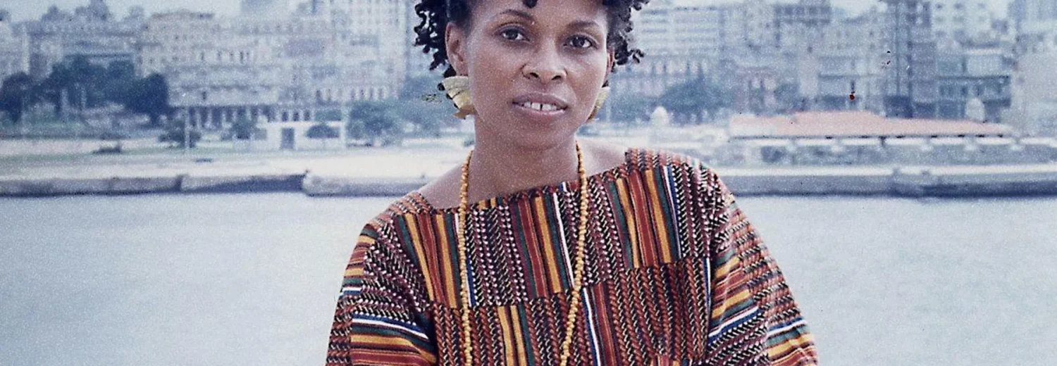 Assata Shakur sitting on the waterfront with the backdrop of the city